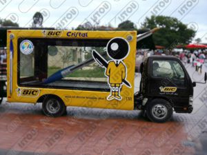 Une grande sculpture stylo en résine et fibre de verre renforcée par une armature métallique montée sur une voiture