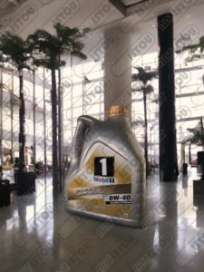 Une grande sculpture d'un bidon d'huile de voiture de Mobil 1 en résine et fibre de verre renforcée par une structure en fer antirouille.