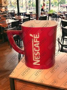 Sculpture d'une tasse Nescafé en résine et fibre de verre renforcée d'une armature métallique