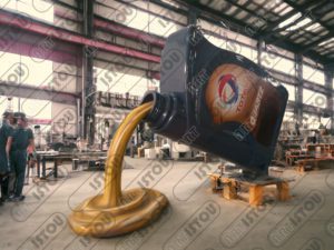 Une grande sculpture d'un bidon d'huile de voiture de Total quartz en résine et fibre de verre renforcée par une structure en fer antirouille.