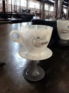 Une table haute en forme de tasse à café pour vous donner une sensation d'intégration au milieu. Fabriquée en résine, fibre de verre et peinture acrylique.