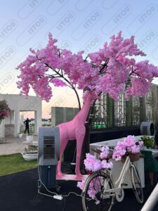 Sculpture de girafe couleur rose fuchsia, présentée en mise en scène artistique.