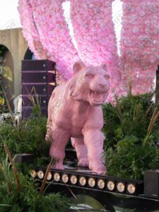 Sculpture de tigre couleur rose fuchsia, présentée en mise en scène artistique.