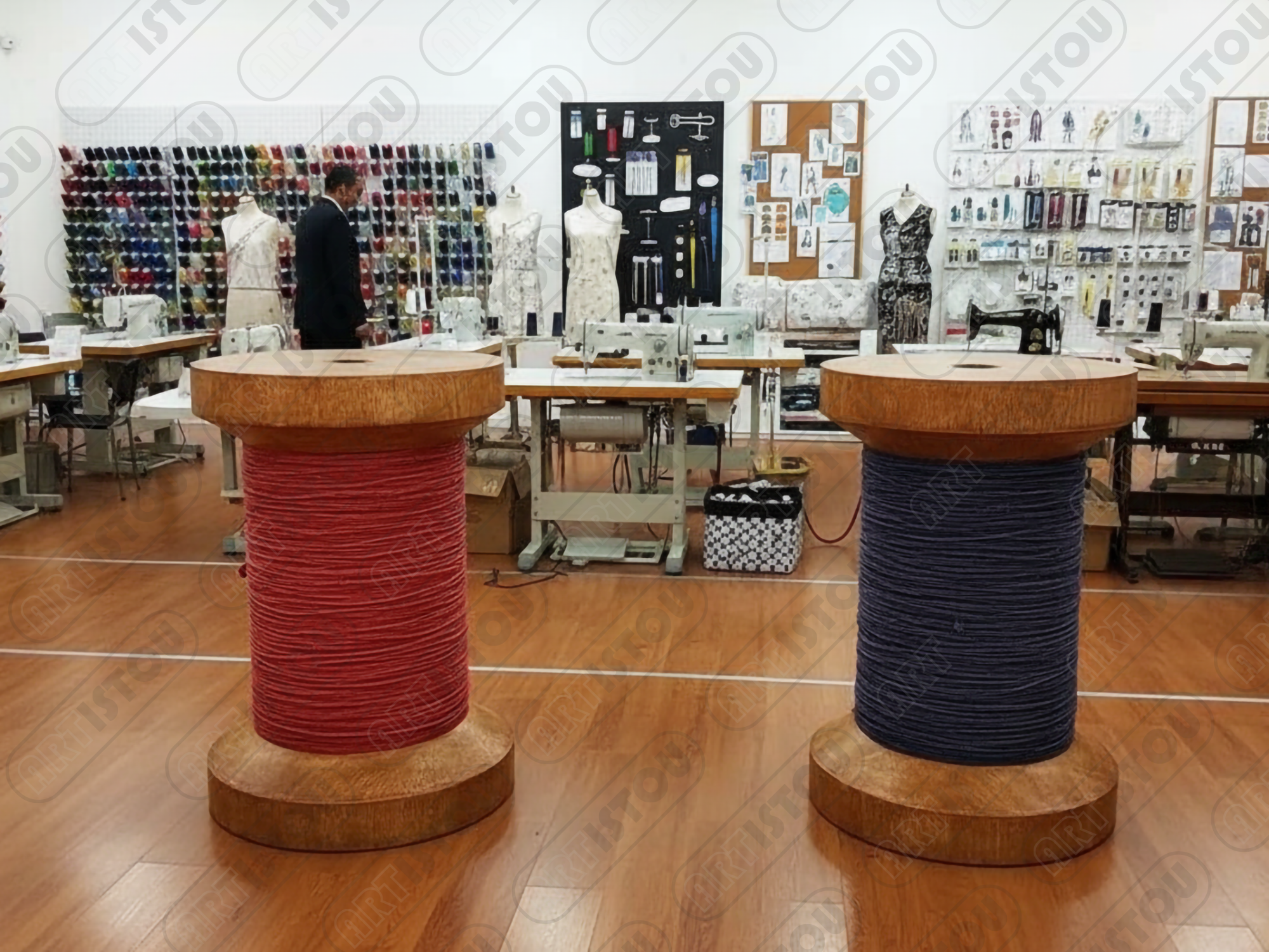 Une nature morte artistique disposée sur une table en bois rustique. Au centre, un cadre doré richement orné entoure une toile de lin sur laquelle reposent des bobines de fil en bois (rouge, bleu, crème), des échevettes de coton à broder, une variété de boutons (nacre, bois, métal) et une aiguille à coudre piquée avec précision. Cette composition évoque le savoir-faire traditionnel et l'élégance de la couture à la main.